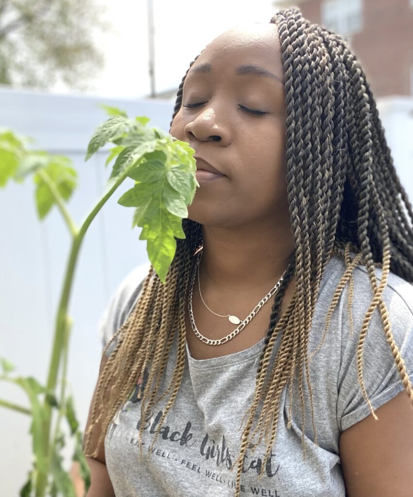 Woman smelling the scent of tomato plant