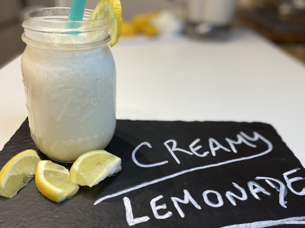 Creamy Lemonade in a mason jar on a chalk tablet with the words creamy lemonade written out.