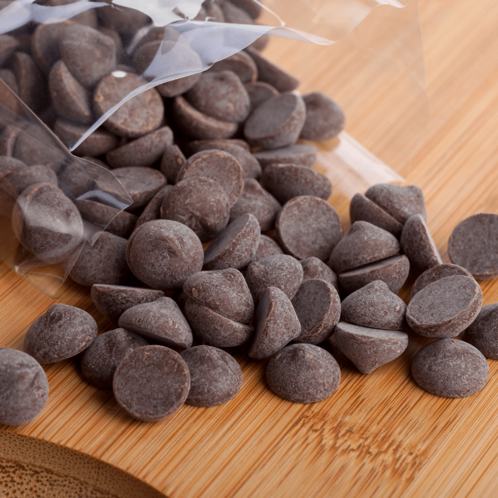 Milk chocolate chips on a cutting board.