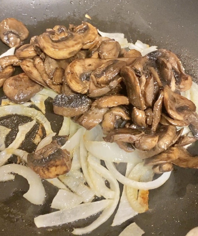 mushrooms and onions  cooking in a sautee pan