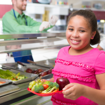 School Age Girl on School Cafeteria Line with Tray of Fruits and Vegetables