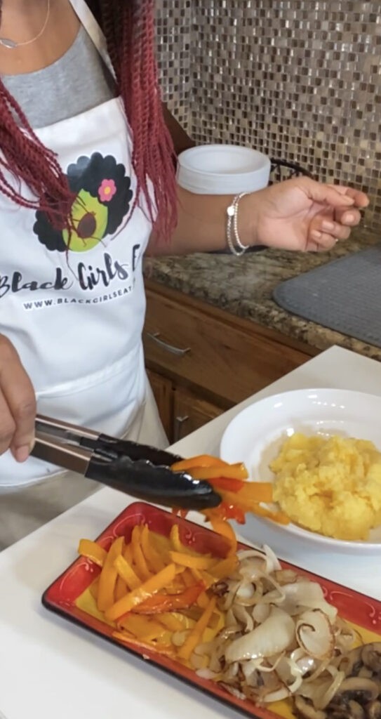 woman adding polenta and vegetables to a plate