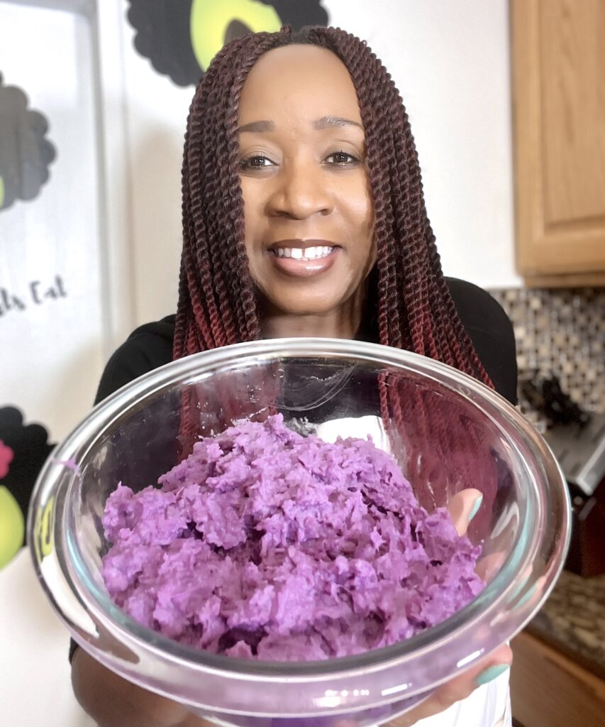 Woman holding bowl of mashed purple potatoes