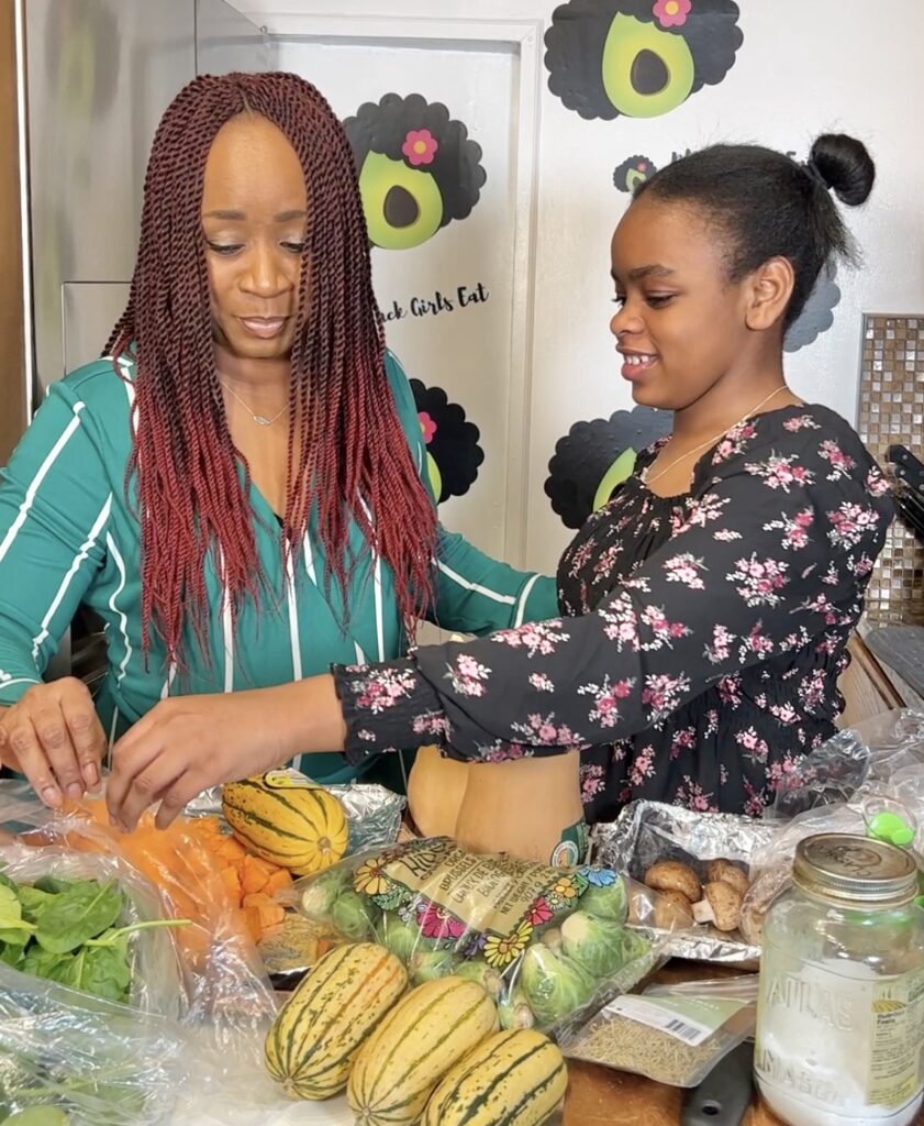 Mom and Daughter with a table of vegetables