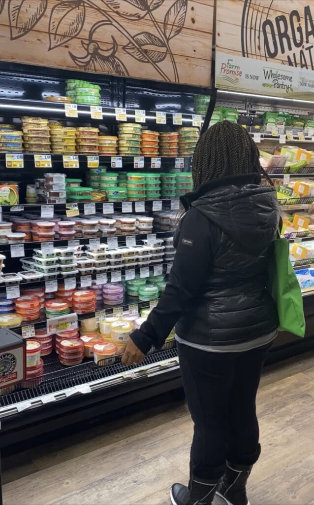 Woman In Front of Refrigerated Foods 
