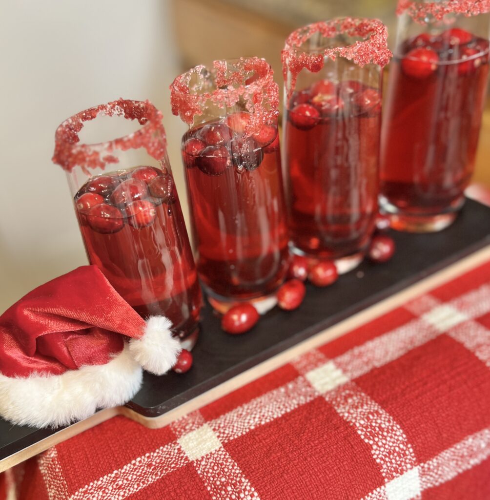 4 glasses of prosecco with cranberry juice and cranberries with a red sugar rim