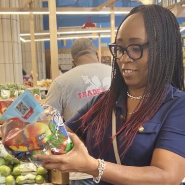 Woman looking at a bag of apples in the produce section