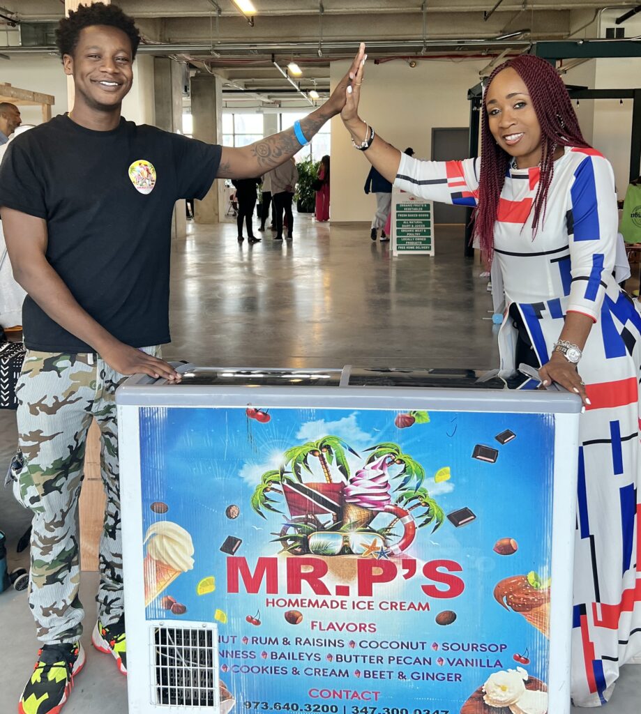 Man and woman giving a high five over an ice cream cart filled with vegan and plant based options