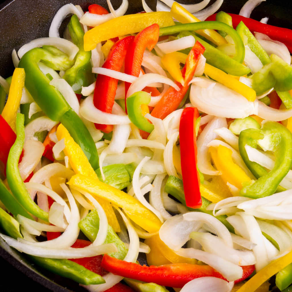 Bowl of onions, red, yellow and green peppers

