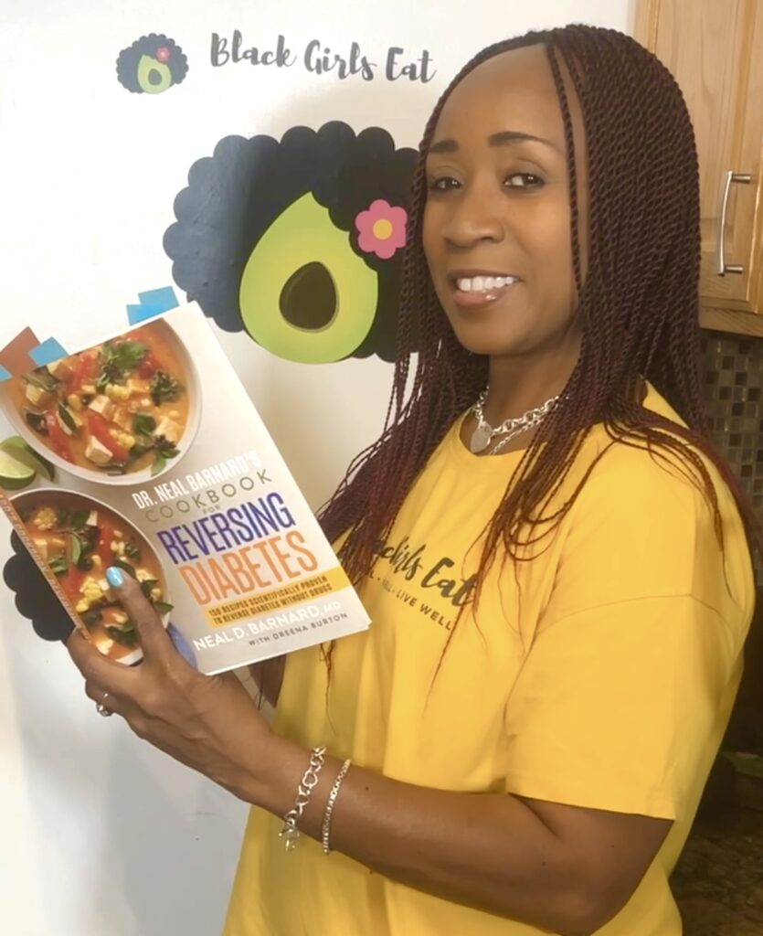 Woman holding copy of Dr. Neal Bernard's Cookbook for Reversing Diabetes