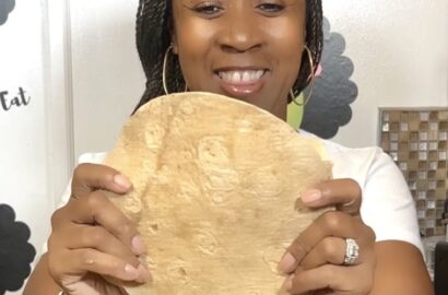 woman holding a tortilla in front of her
