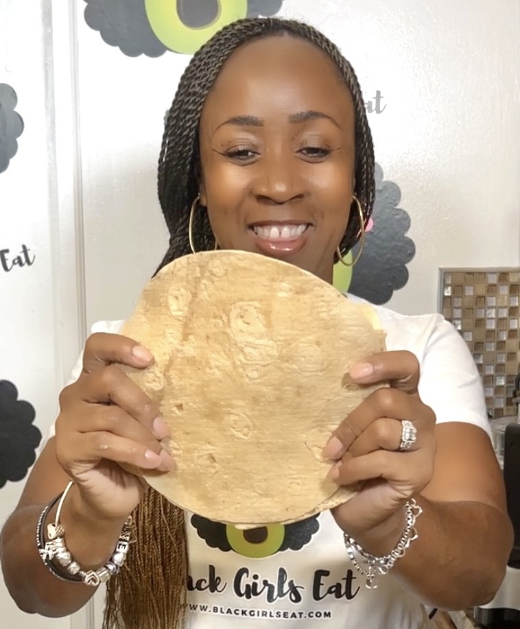 woman holding a tortilla in front of her