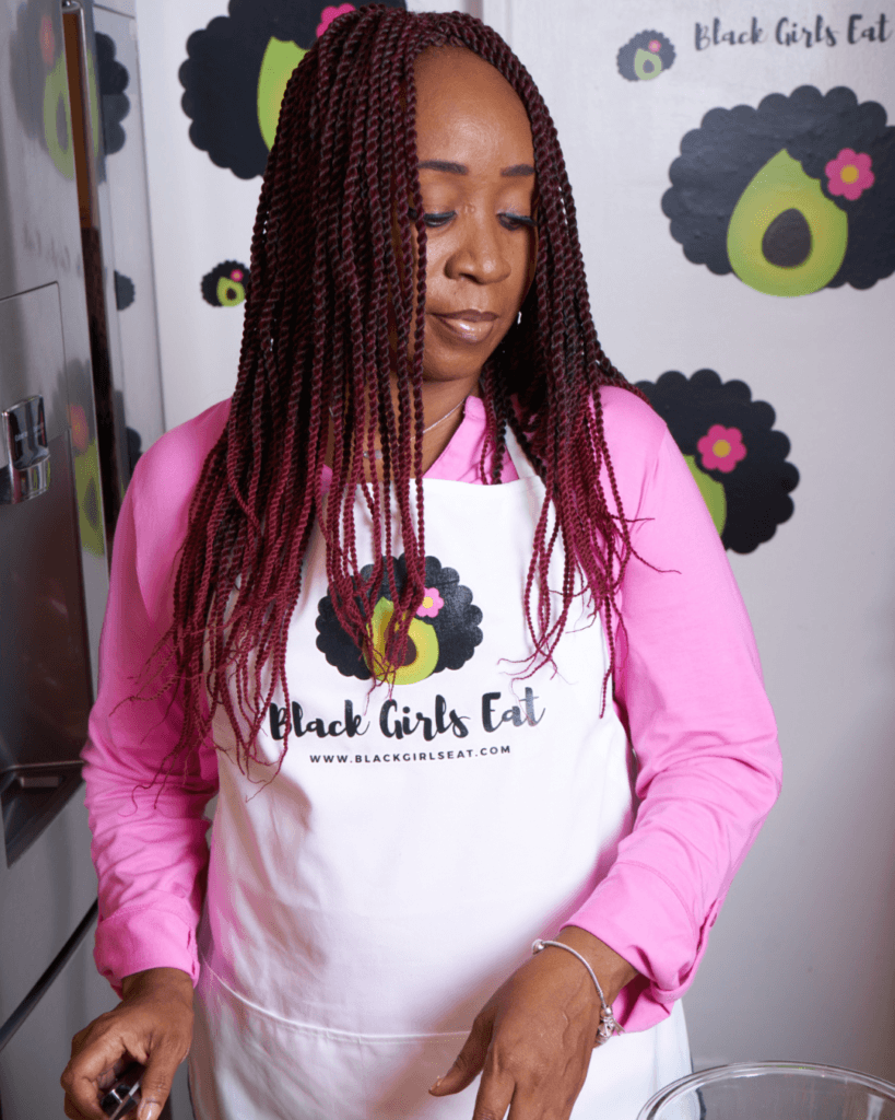 Woman in Kitchen with Black Girls Eat apron on ready for a plant-based January
