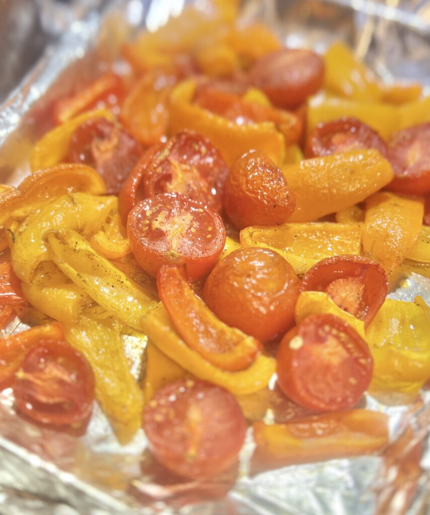 Roasted tomatoes and peppers on a cookie sheet