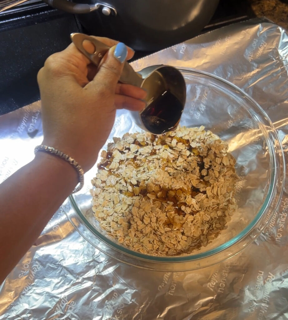 Bowl of rolled oats with maple syrup being added
