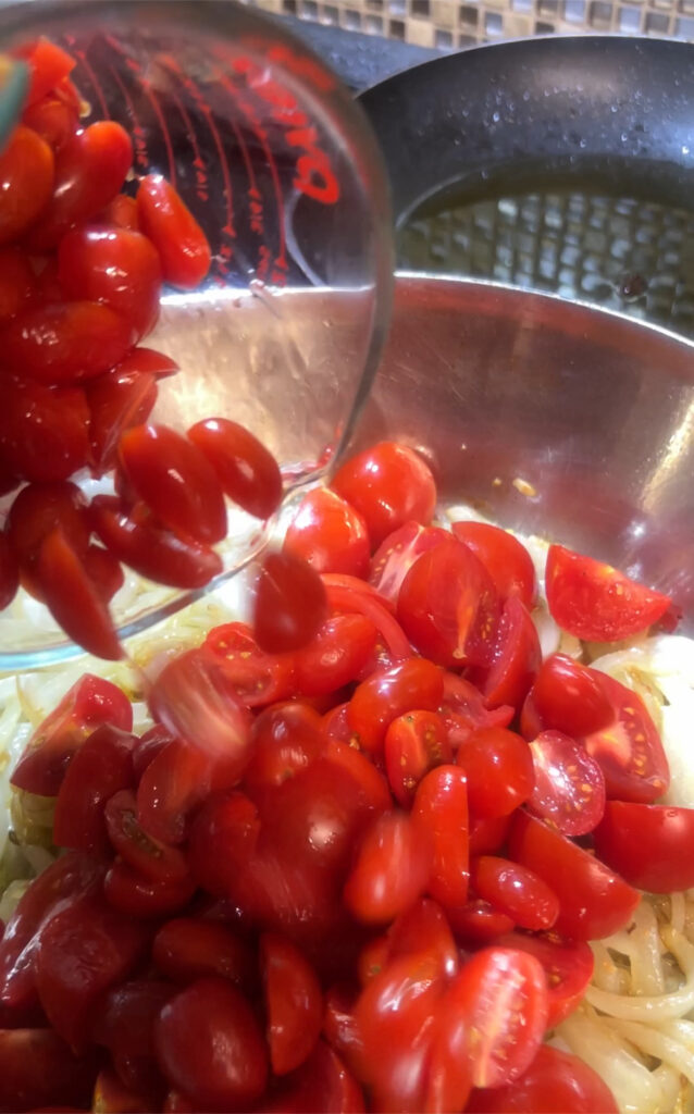 Cherry tomatoes in pan with onions