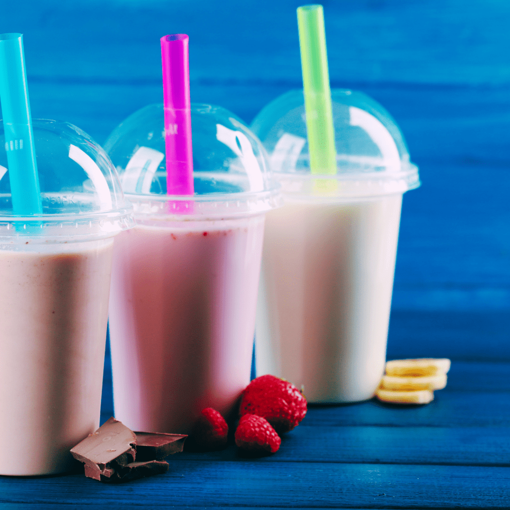 3 Milkshakes in plastic cups with straws