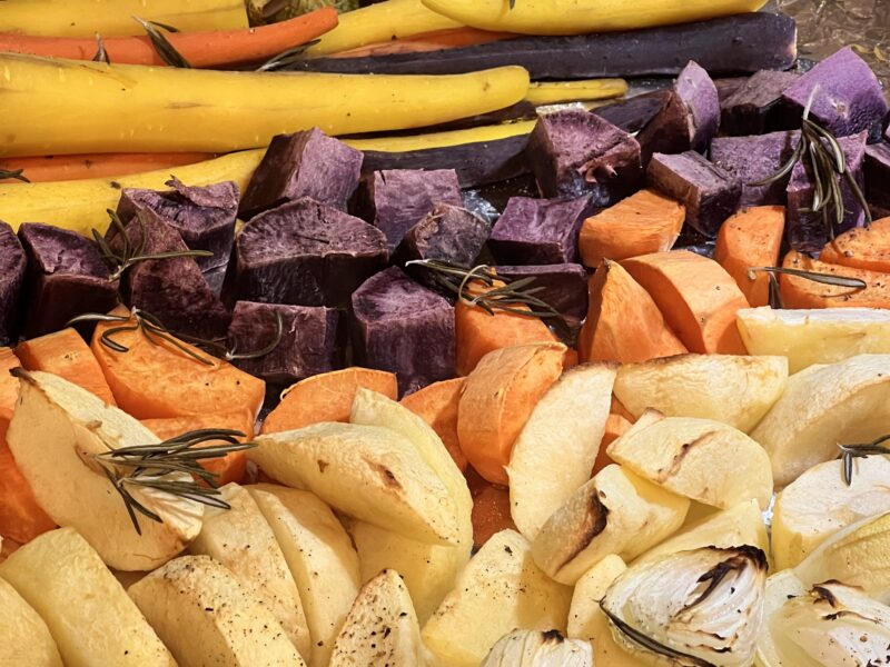 Roasted vegetables including carrots, sweet potatoes, onions and apples are ready for a sheet pan dinner