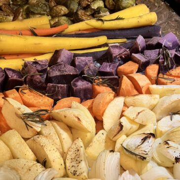 Roasted vegetables including carrots, sweet potatoes, onions and apples are ready for a sheet pan dinner