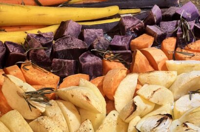 Roasted vegetables including carrots, sweet potatoes, onions and apples are ready for a sheet pan dinner