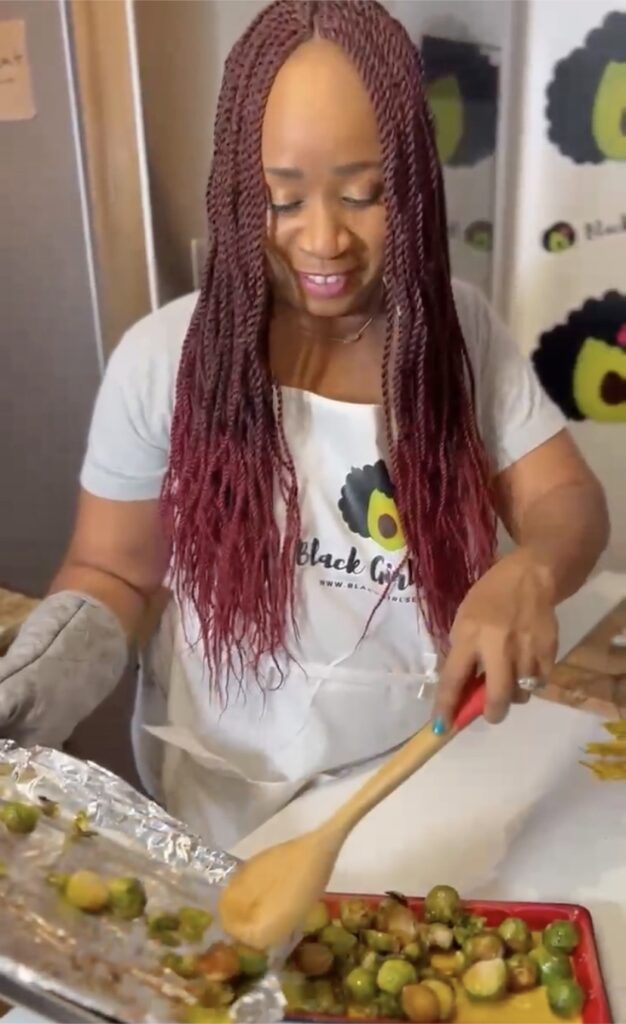 woman with a baking sheet of Brussells sprouts