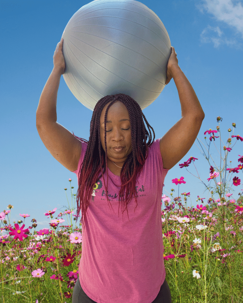 Woman holding a stability ball is an example of plant-based wellness that goes beyond food