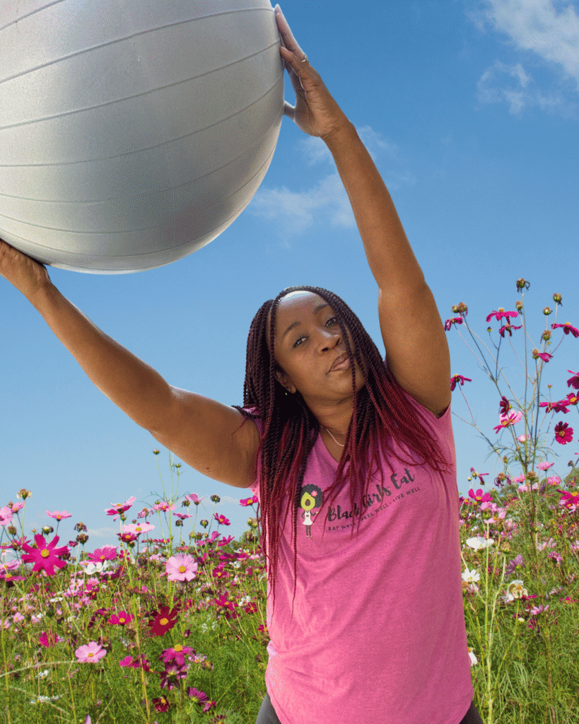 A woman stretching with a stability ball. Moving the body is an example of plant-based wellness beyond food.