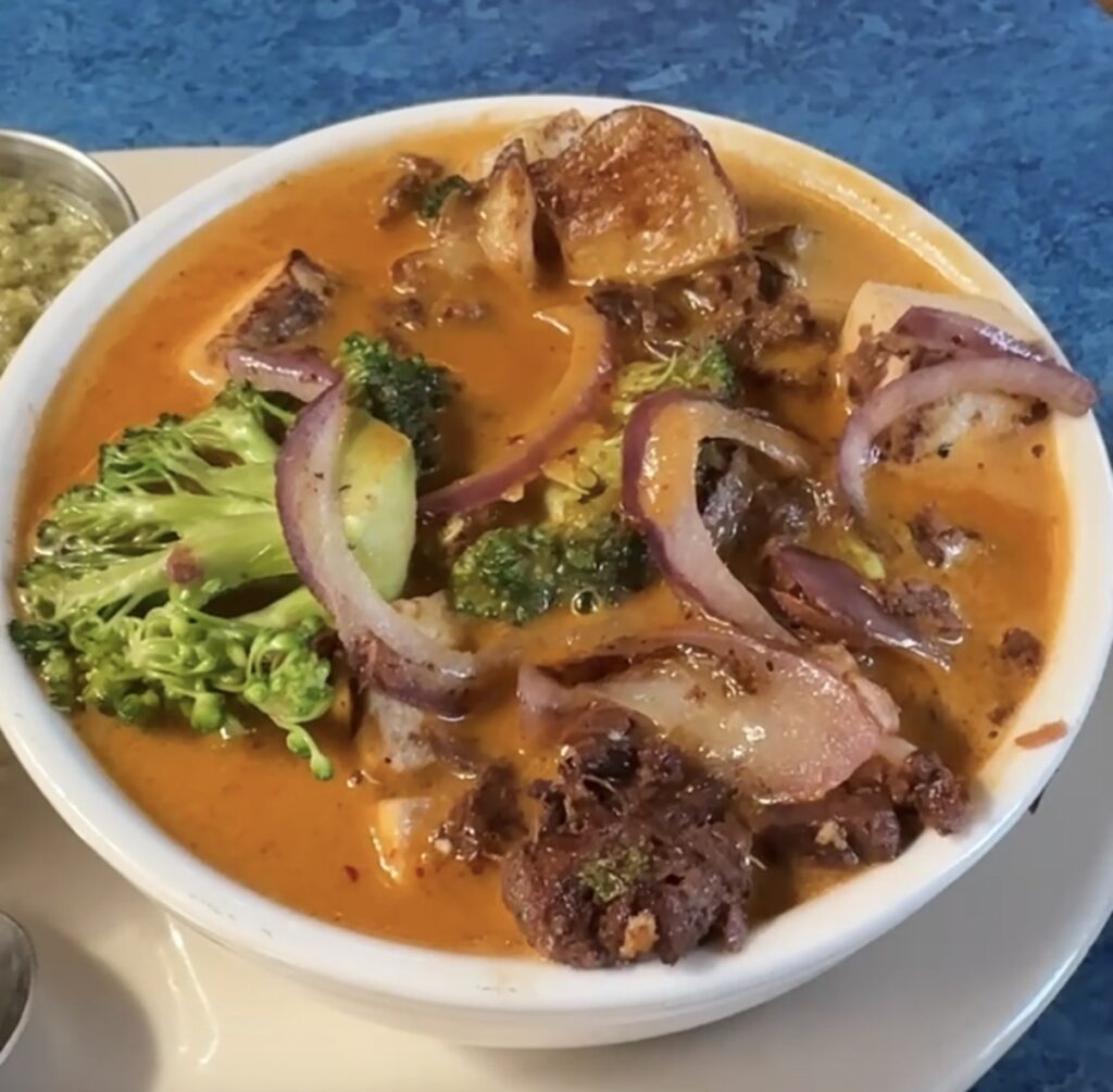 A bowl of Jackfruit Curry with potatoes, broccoli and red onions was the perfect solo dining experience