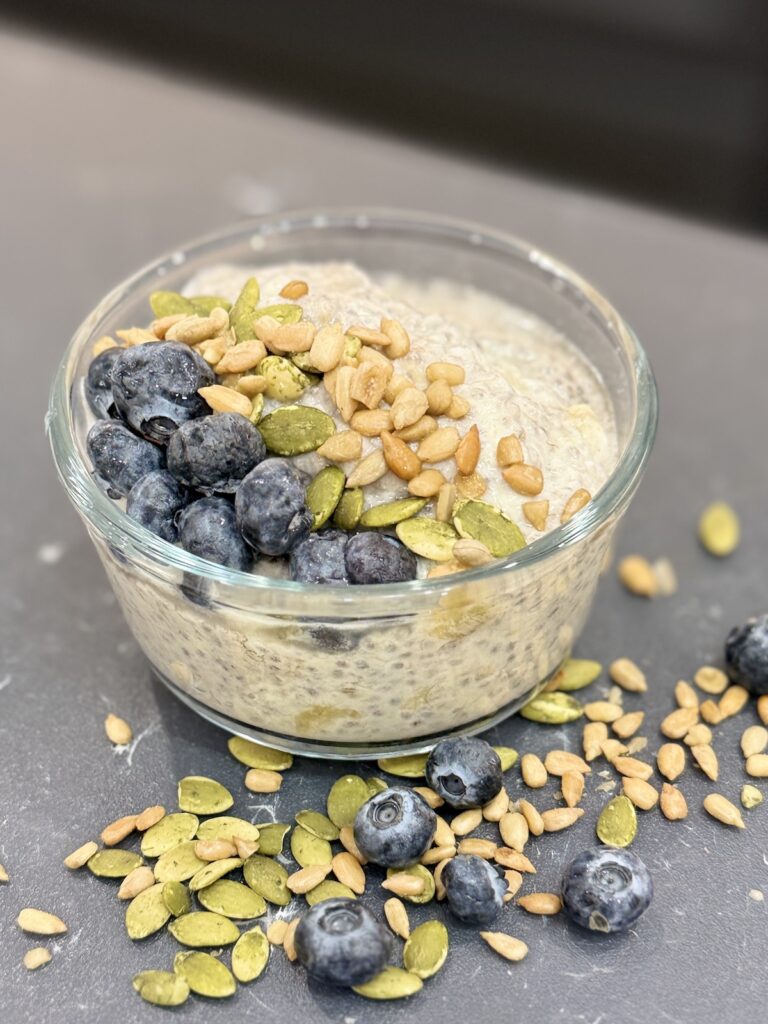 Bowl of Banana Chia Seed Pudding topped with blueberries, pumpkin seeds and sunflower seeds